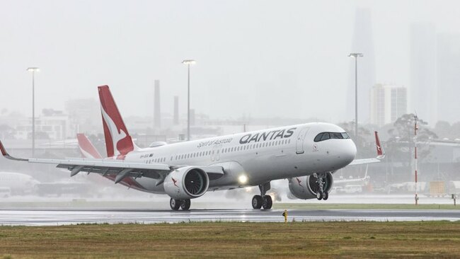 The long-awaited new Qantas plane touches down in soggy Sydney